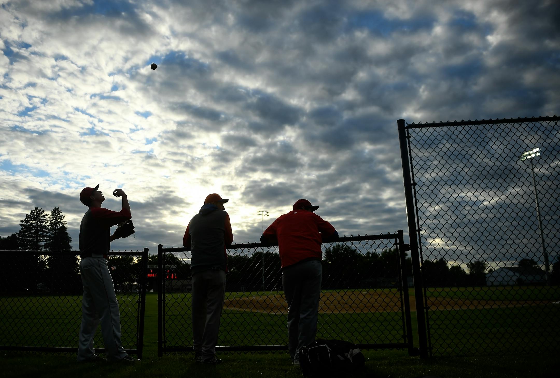 Farming players hung out on the fence along the third baseline before their game against the Sartell Muskies on Friday, June 23, 2017 during the Farming Invitational tournament in Farming, Minn. .