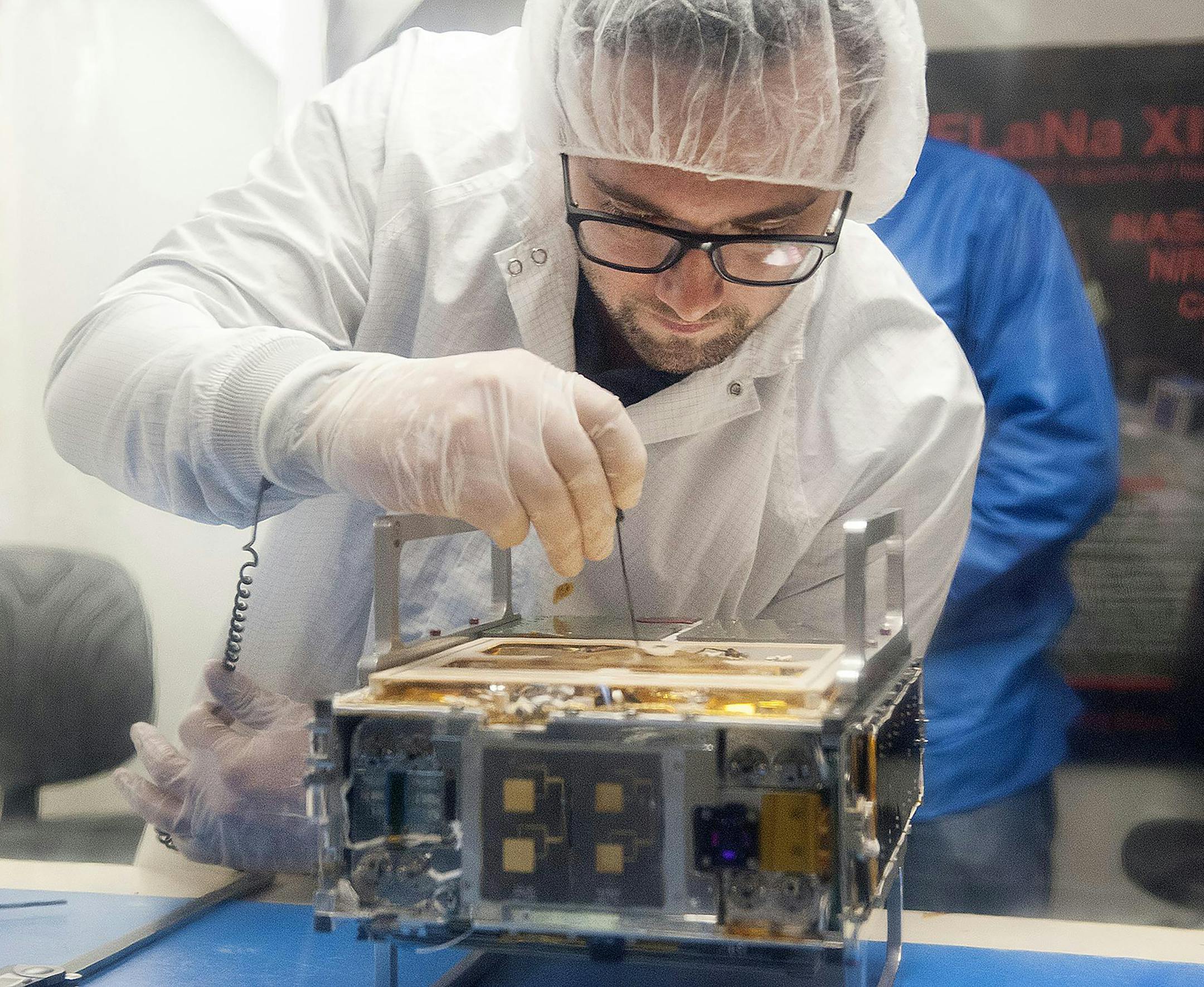 **EMBARGO: No electronic distribution, Web posting or street sales before Tuesday 2:30 a.m. ET Dec. 11, 2018. No exceptions for any reasons. EMBARGO set by source.** A handout photo provided by NASA/JPL-Caltech/Tyvak/Cal Poly SLO shows Joel Steinkraus, an engineer at NASA’s Jet Propulsion Laboratory, as he adjusts a Mars Cube One satellite on March 12, 2018. Orbiting instruments are now so small they can be launched by the dozens, and even high school students can build them. (NASA/JPL-Ca