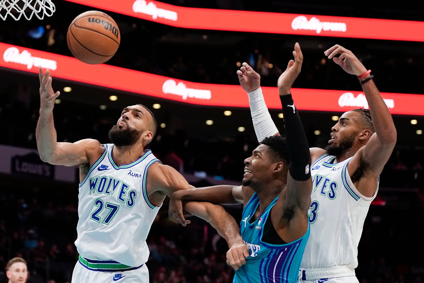 Hornets forward Brandon Miller, middle, vies for the ball with Timberwolves center Rudy Gobert, left, and forward Troy Brown Jr. during the first half Saturday.