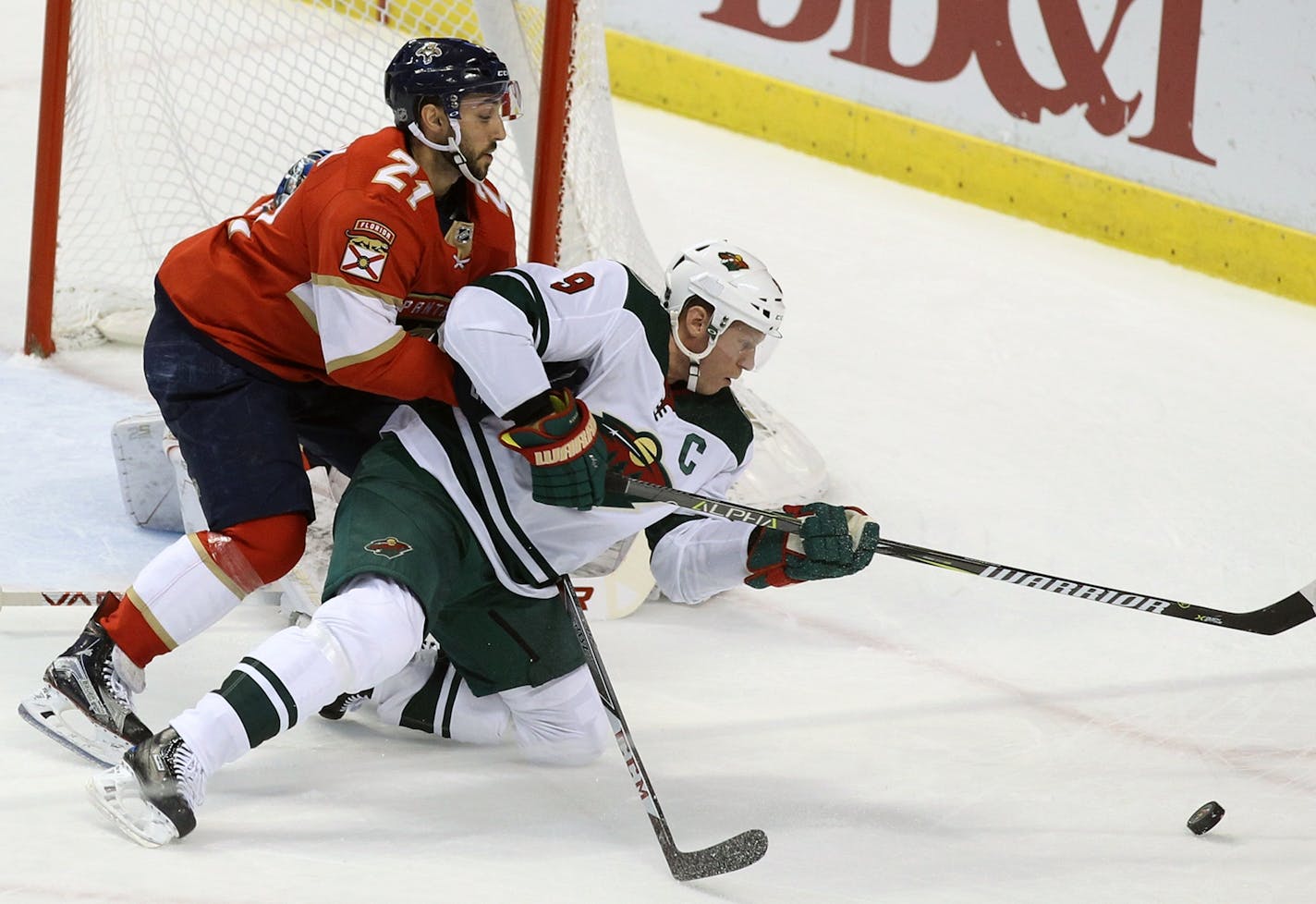 Minnesota Wild's Mikko Koivu (9), of Finland, and Florida Panthers Vincent Trocheck (21) battle for the puck during the first period of an NHL hockey game, Friday, Dec. 22, 2017, in Sunrise, Fla. (AP Photo/Luis M. Alvarez)