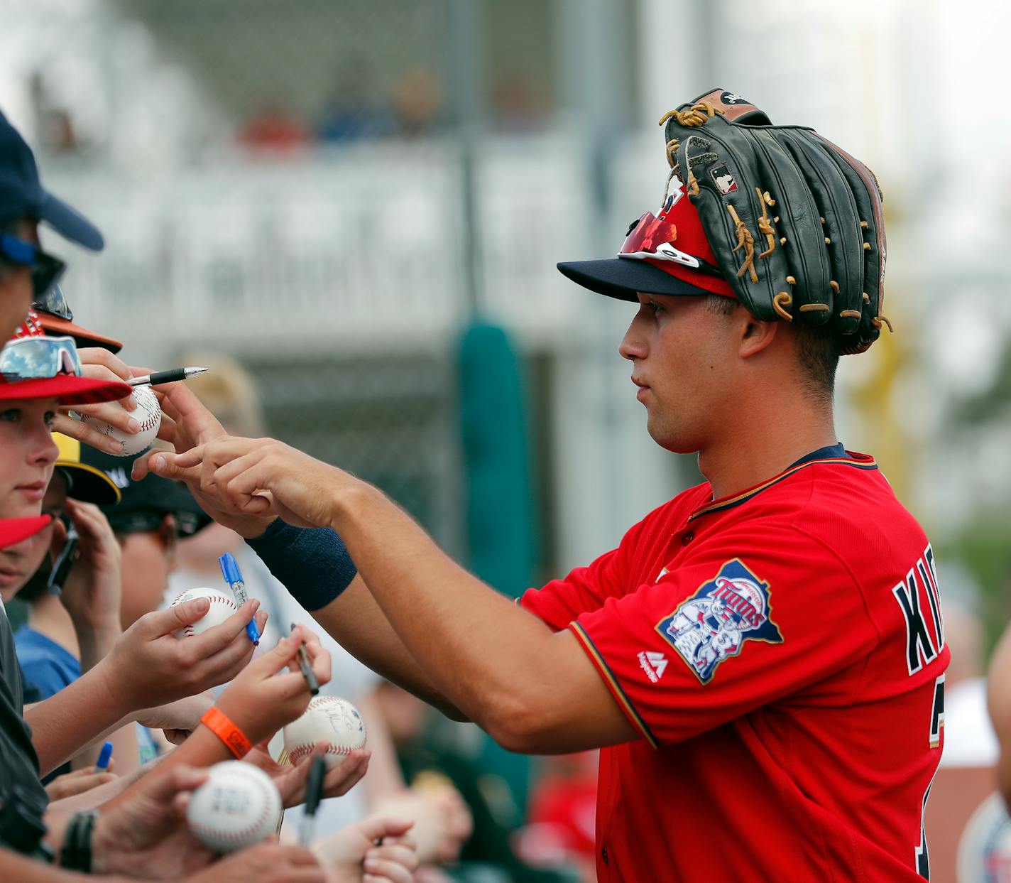 FILE - Minnesota Twins right fielder Alex Kirilloff signs autographs before the start of a spring training baseball game against the Baltimore Orioles in Fort Myers, Fla., in this Monday, March 4, 2019, file photo. Alex Kirilloff has never played in a regular season major league game, but he is on track to become Minnesota's regular left fielder. (AP Photo/John Bazemore, File)