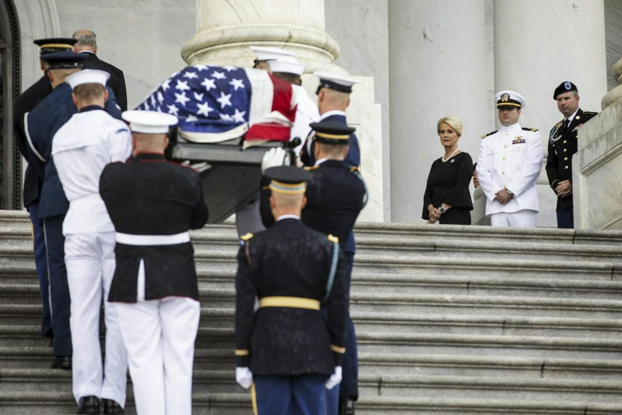 Cindy McCain, third from right, wife of the late Sen. John McCain, watches with her sons, Jimmy, right, and Jack, second from right, as the senator's coffin arrives at the U.S. Capitol, in Washington, Aug. 31, 2018. Sen. John McCain will lie in state in the Rotunda on Friday, the 31st person to receive that honor. (Jim Lo Scalzo/Pool via The New York Times) -- FOR EDITORIAL USE ONLY. --