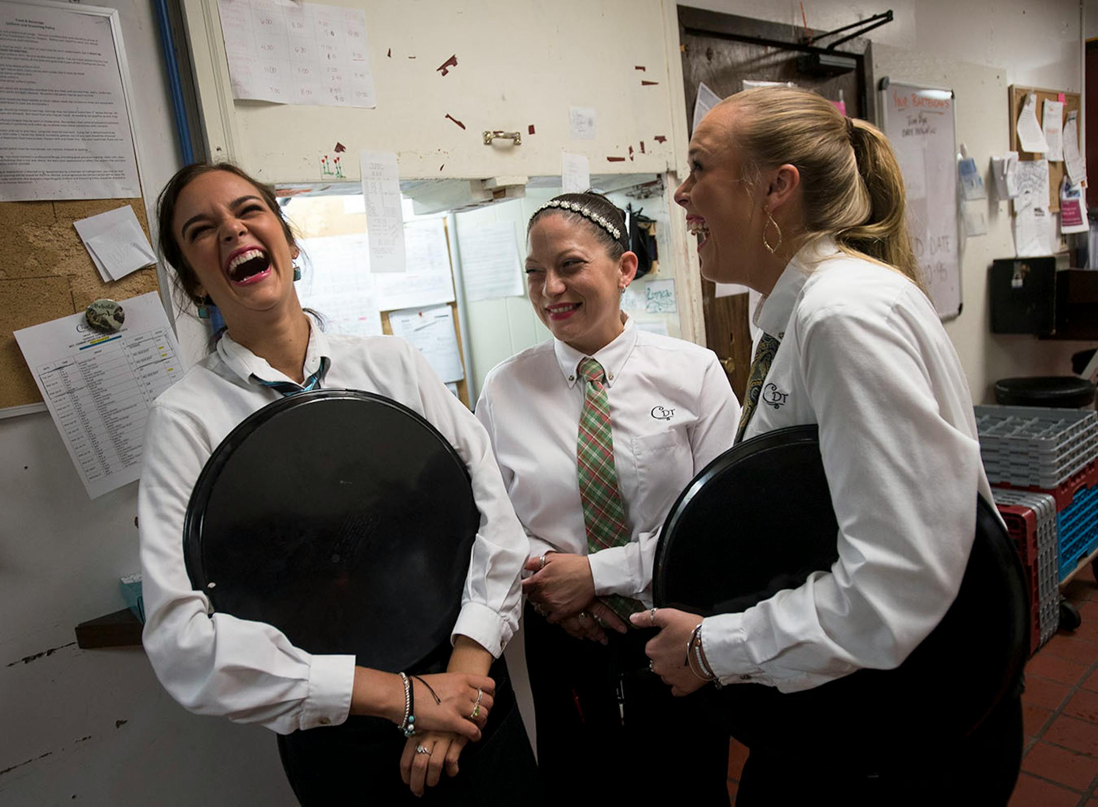 From left, Linnea Lynum, Beth Wegler and Renee Lynum, all servers, shared a laugh during some downtime toward the end of the first act. Intermission is typically the busiest time of the work night, when servers bring out desert and try to close out balances on their tables before the start of the second act.
