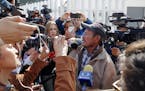 Carlos Catarldo Gomez, of Honduras, right, is surrounded by reporters after leaving the United States, the first person returned to Mexico to wait for