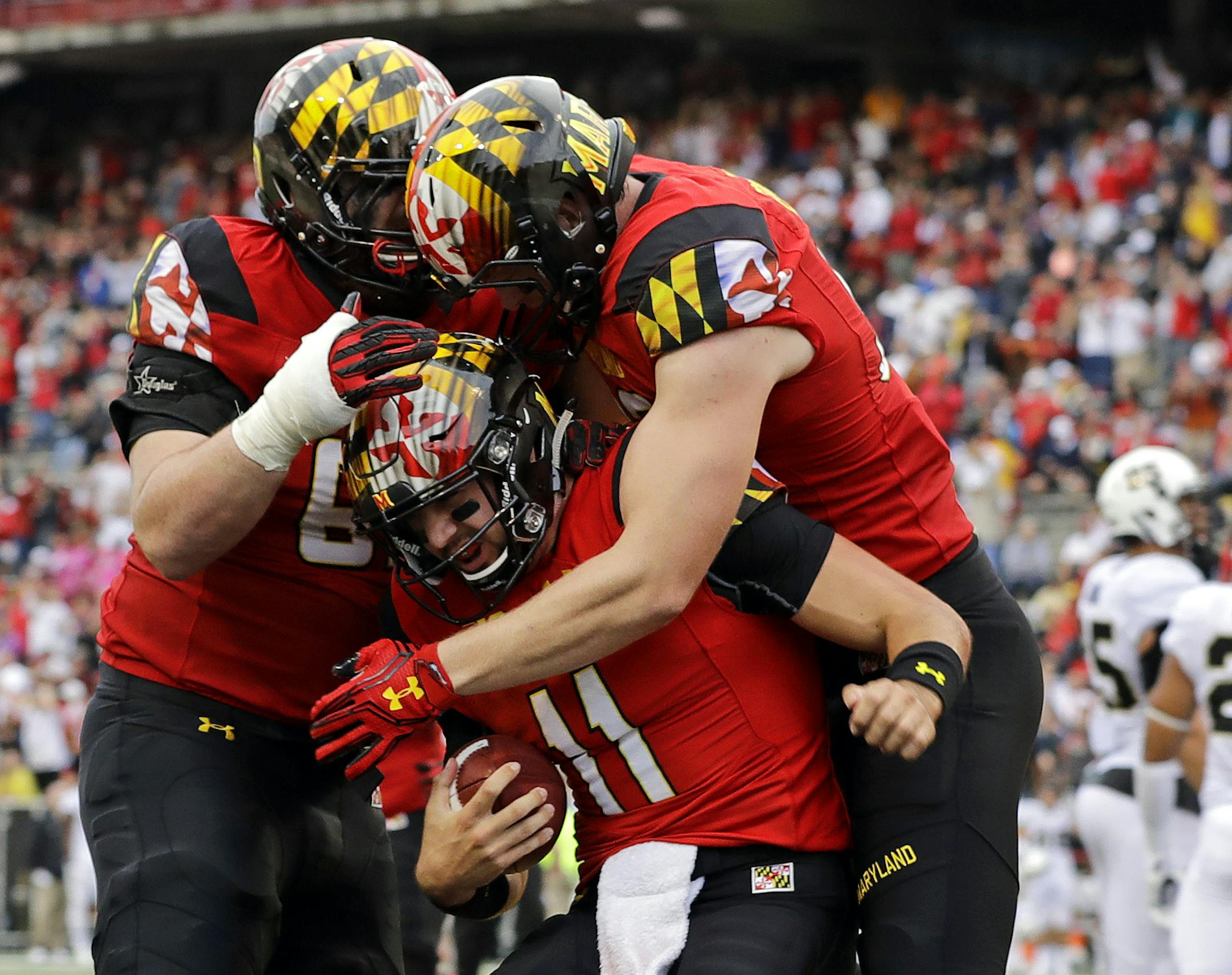 Maryland quarterback Perry Hills (11) celebrates his touchdown with teammates Mike Minter, left, and Avery Edwards in the first half of an NCAA college football game against Purdue in College Park, Md., Saturday, Oct. 1, 2016. (AP Photo/Patrick Semansky)