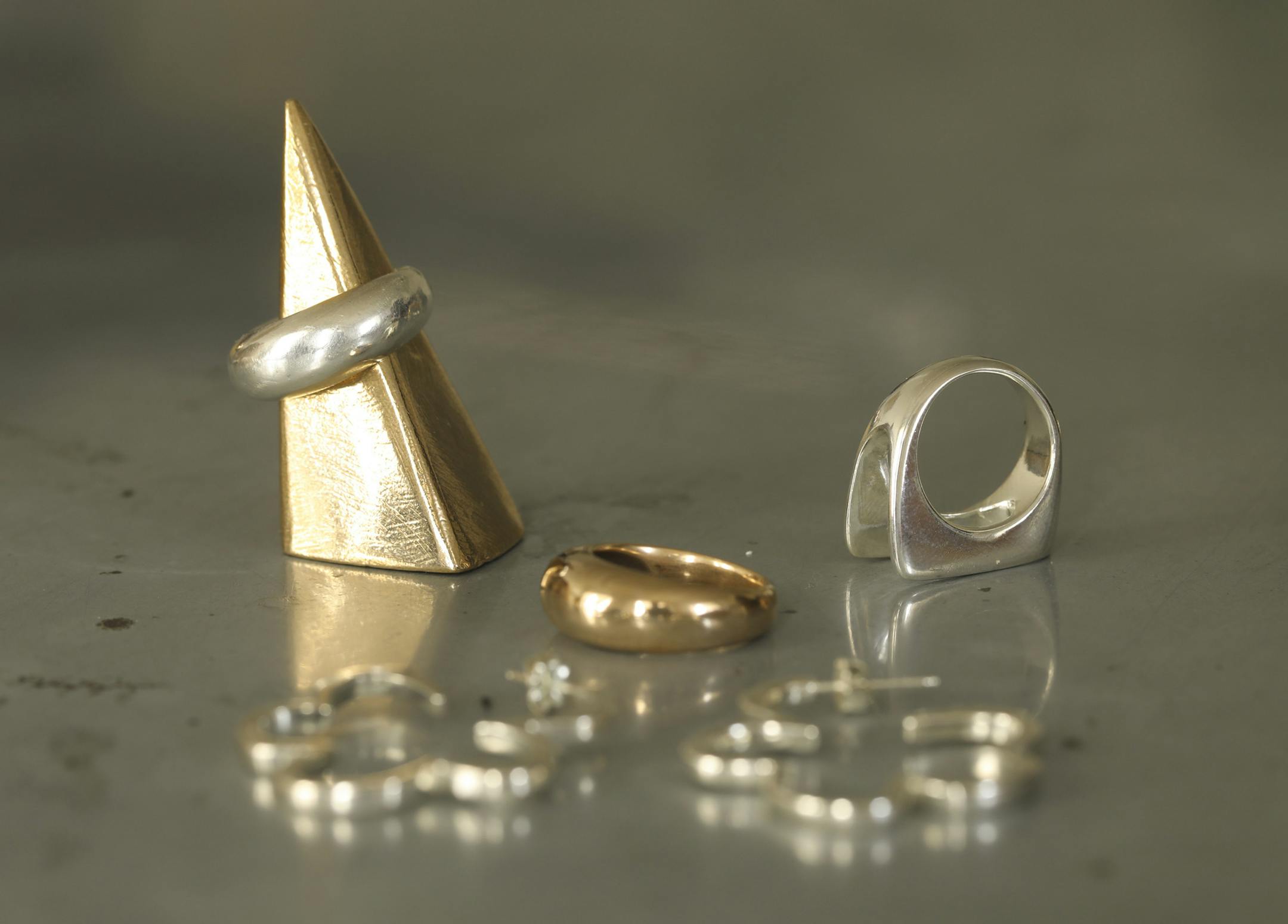 Three rings and a pair of earrings, along with a ring holder, all by Lauren Neal.
