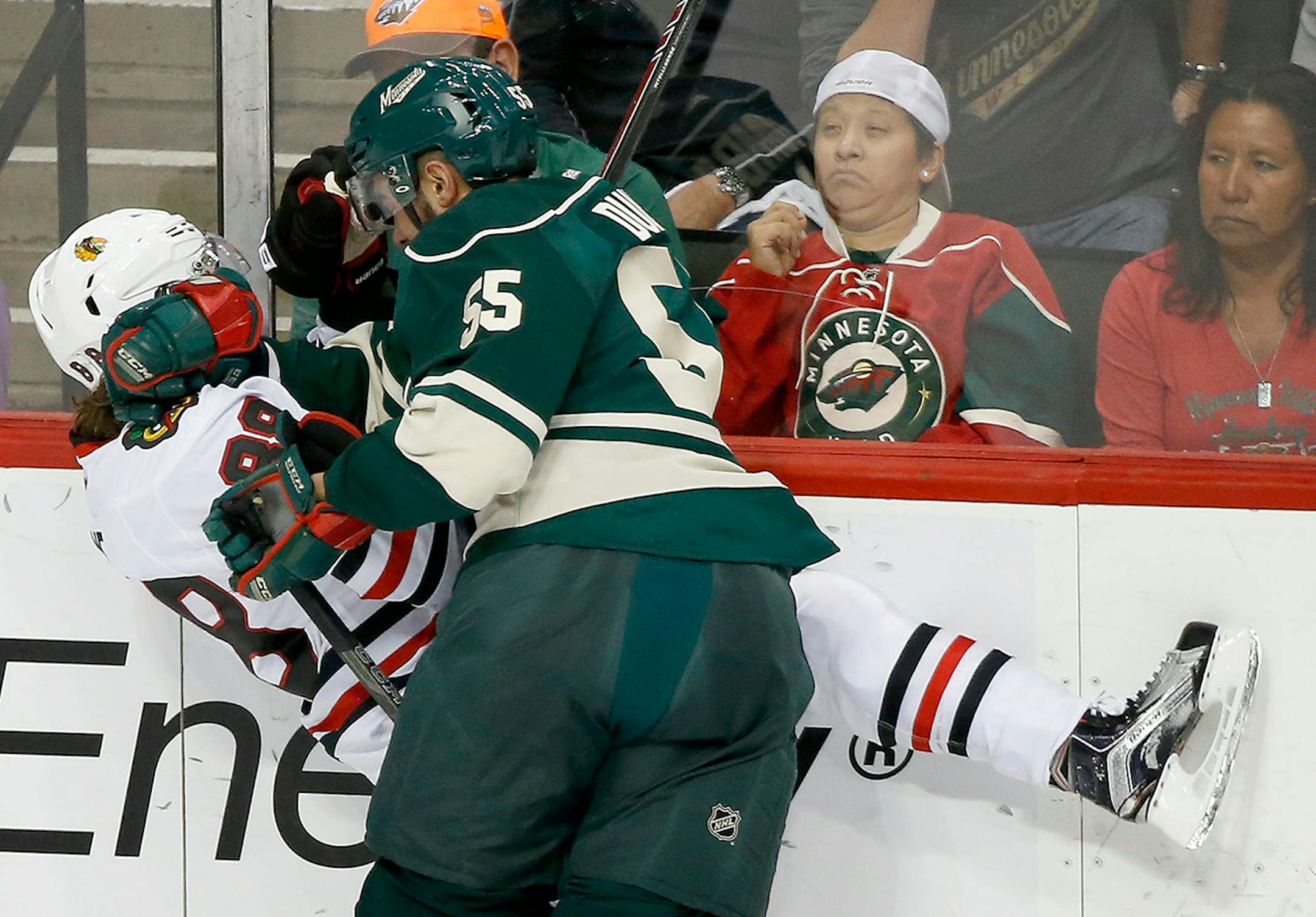 Matt Dumba (55) checked Patrick Kane (88) in the first period.