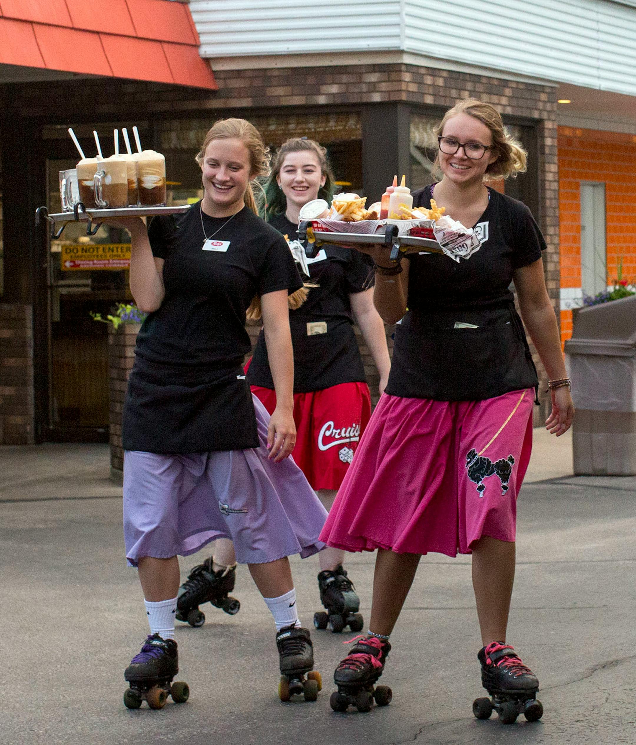 Isabella Chase, Nicole Heller and McKenna Fellegy (from left to right) roller skate with trays of food and drinks to customers at Rudy's Drive-In. ] COURTNEY PEDROZA • courtney.pedroza@startribune.com June 22-24, 2017; Wisconsin restaurants, cafes, bars, bakeries and breweries; Dining along the Mississippi River.