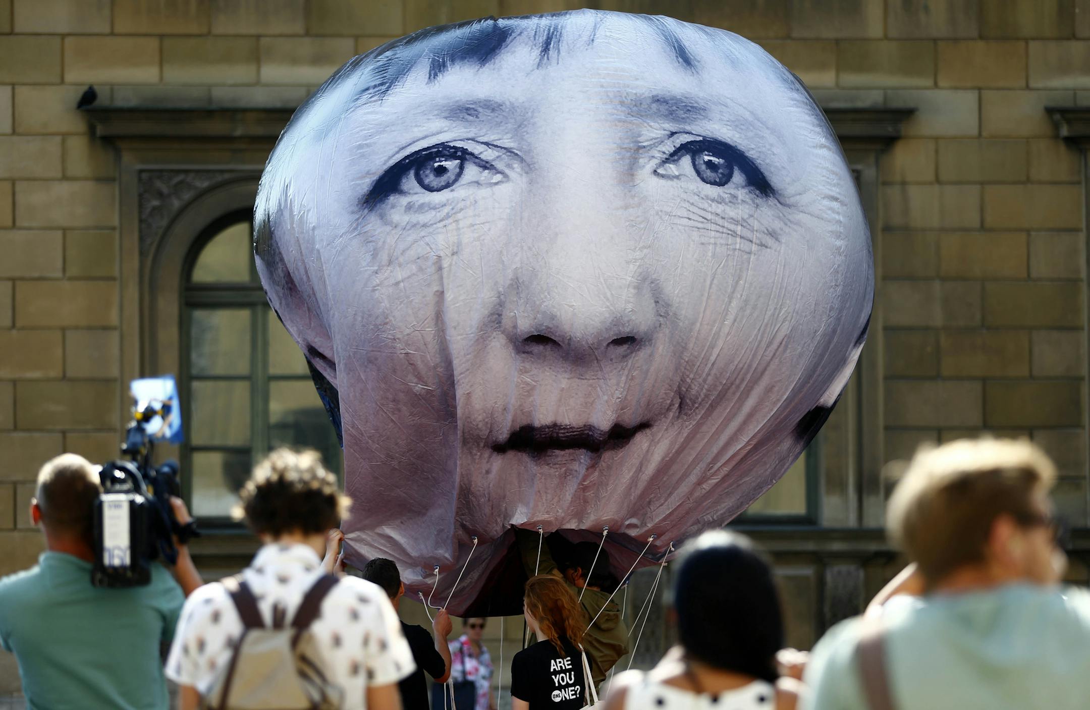 Activists of the international campaigning and advocacy organization ONE prepare a balloon with a portrait of German chancellor Angela Merkel during a protest against the upcoming G-7 summit in Munich, Germany, Friday, June 5, 2015. (AP Photo/Matthias Schrader)