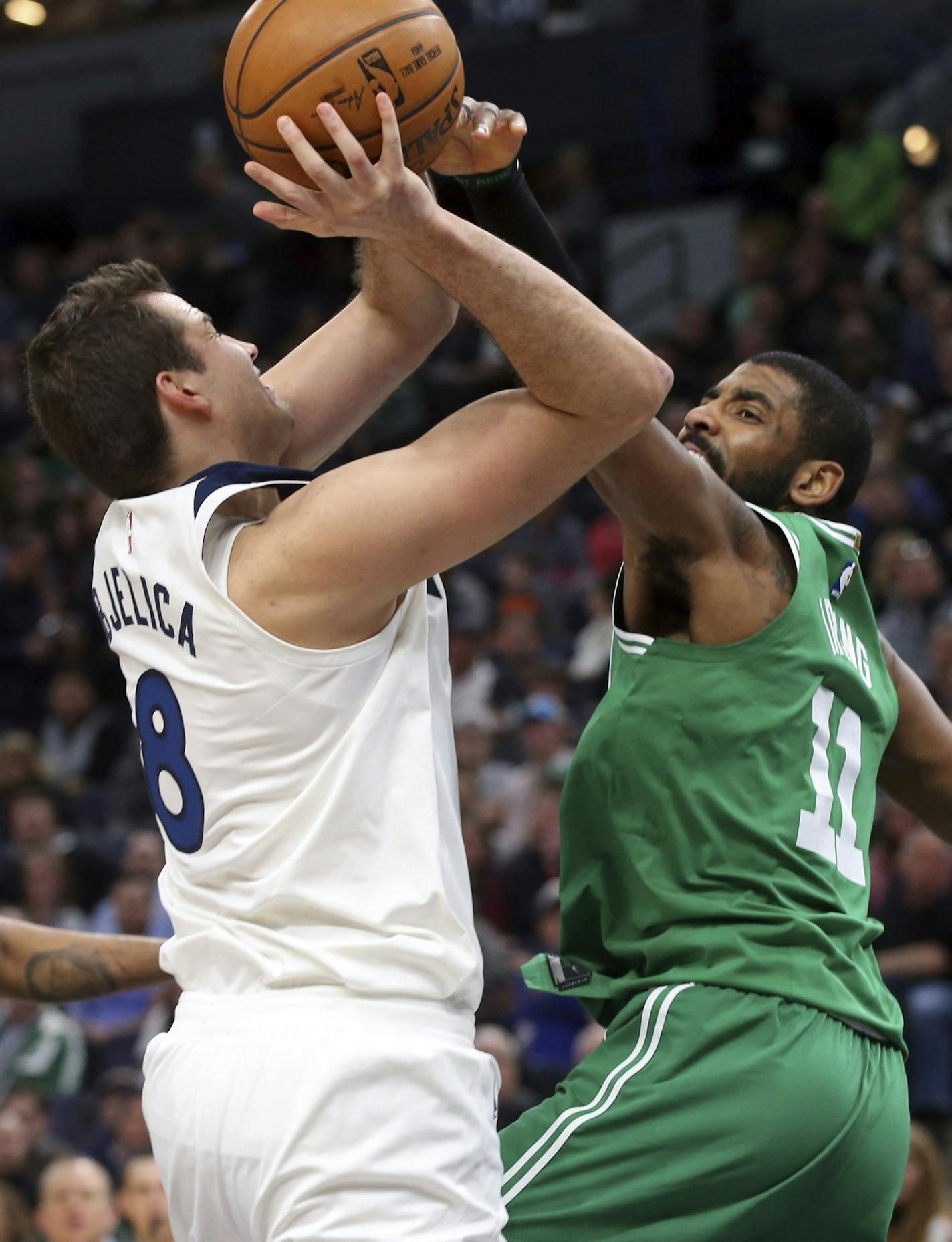 Minnesota Timberwolves' Nemanja Bjelica of Serbia shoots as Boston Celtics's Kyrie Irving, right, tries to block the shot in the second half of an NBA basketball game Thursday, March 8, 2018, in St. Paul, Minn. The Celtics won 117-109. (AP Photo/Jim Mone)