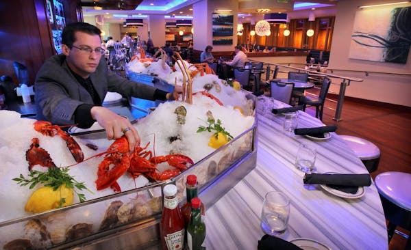 Oceanaire Seafood Room Manager, Jacob Uttich, straightens out the raw oyster bar. Restaurant review. The raw bar at the front of the restaurant, shuck