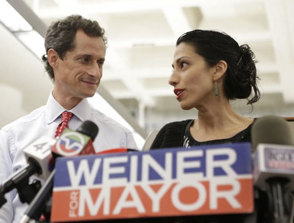 Huma Abedin, alongside her husband, New York mayoral candidate Anthony Weiner, speaks during a news conference at the Gay Men's Health Crisis headquar