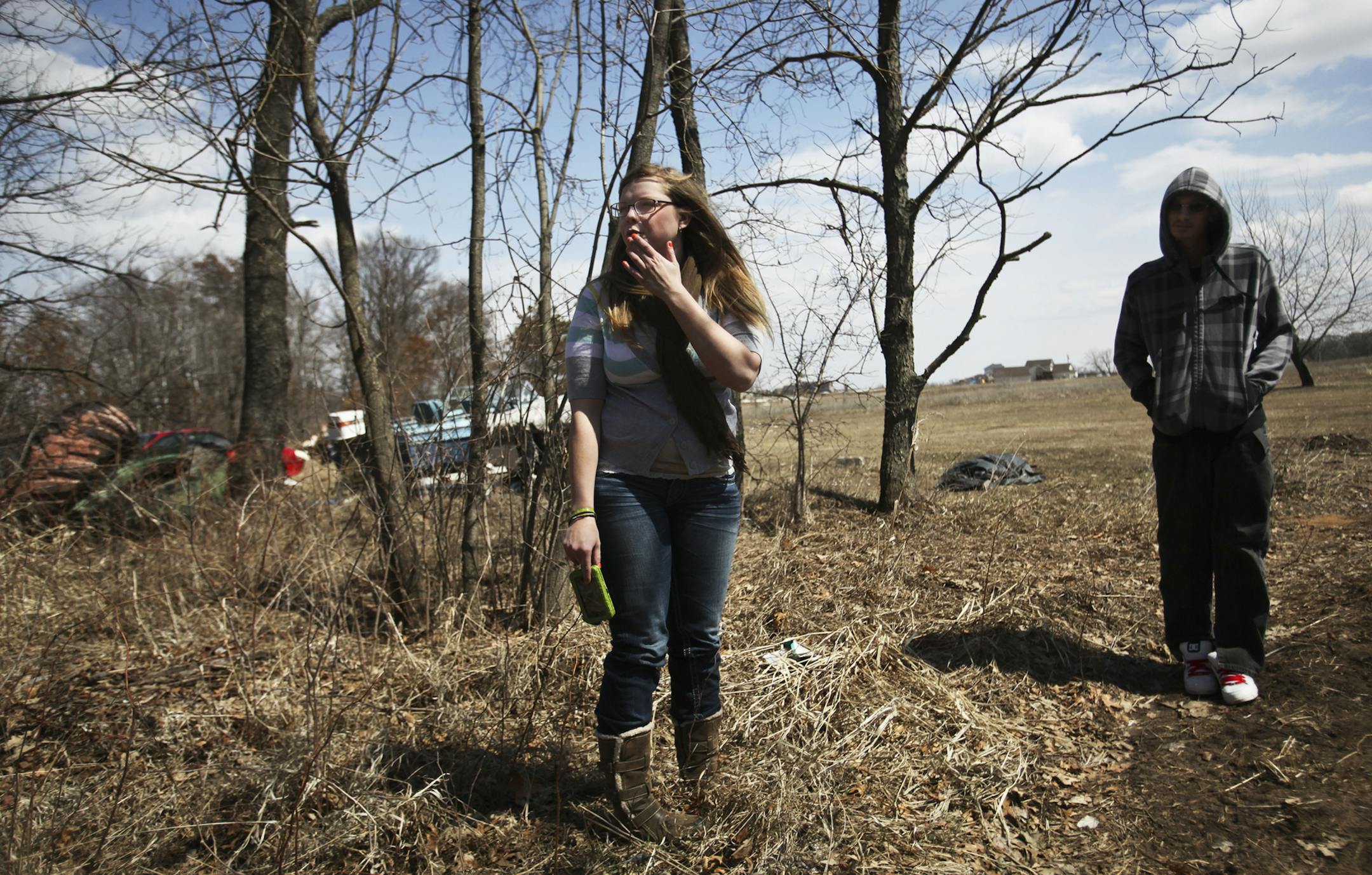 Trinity Fletcher, 20, stands on the edge of a woods where she lived in a tent for about a year with her boyfriend Jessie, right, while she was attending high school. She was photographed Wednesday, April 24, 2013 in St. Francis, MN.