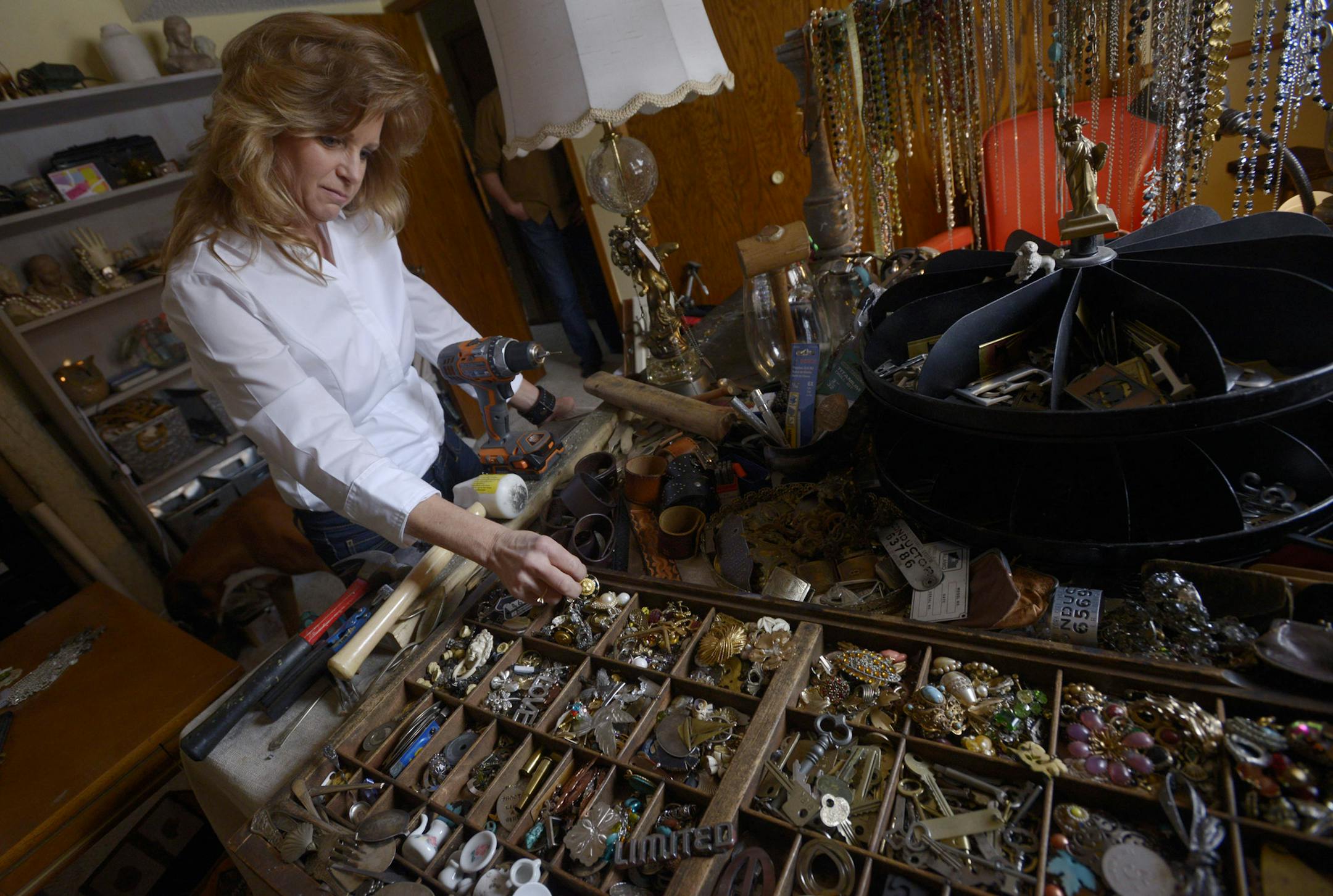 Brenda Weber looks through her collection of old jewelry and trinkets at their home in Burnsville, Minn. Brenda makes jewelry out of old typewriter keys, and her husband, Tom, makes lawn ornaments out of old silverware and decorative "flags" out of old baseball balls and bats.