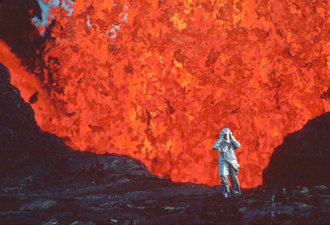 Volcanologist Katia Krafft, wearing an aluminized suit near a lava burst at Krafla volcano in Iceland, in a scene from “Fire of Love.”