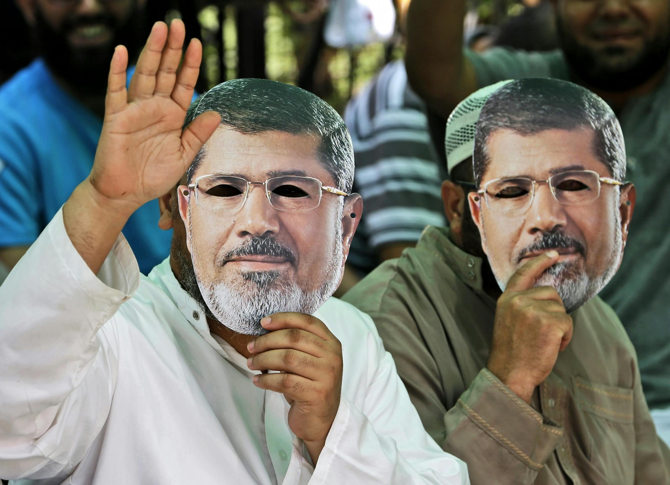Supporters of Egypt's ousted President Mohammed Morsi wear masks with the former leader's likeness during a demonstration where protesters have installed their camp, at Nasr city, Cairo, Egypt, Friday, July 19, 2013. Thousands of protesters are holding rallies across Egypt to demand the reinstatement of ousted President Mohammed Morsi. The Muslim Brotherhood, from which Morsi hails, is mobilizing followers to march in Cairo and elsewhere Friday for a protest they�re dubbing "Breaking the Coup.�