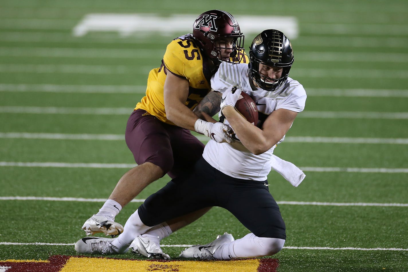 Purdue tight end Payne Durham, right, is tackled by Gophers  linebacker Mariano Sori-Marin (55) during the second half on Nov. 20