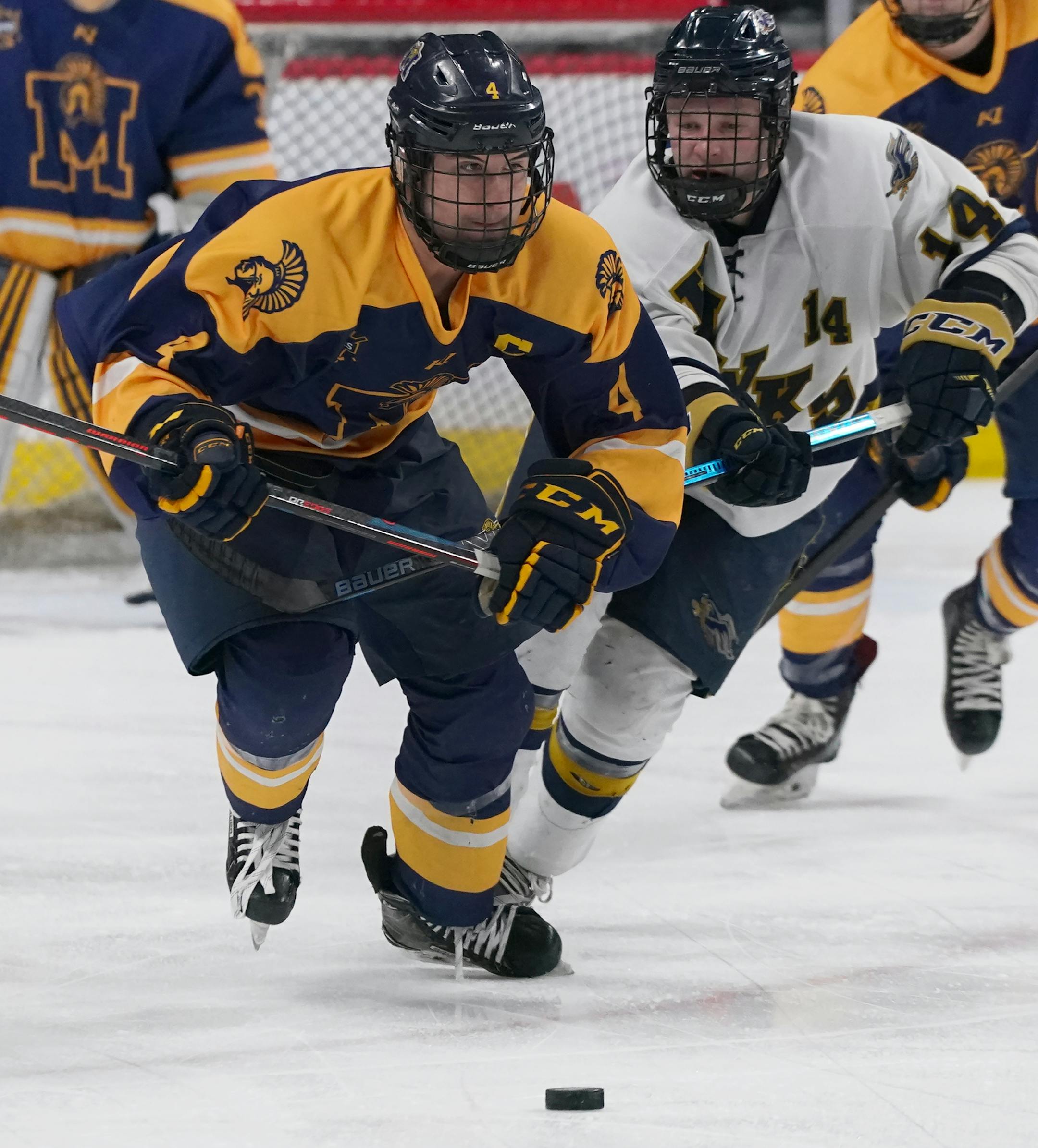 Mahtomedi forward Colin Hagstrom (4) skated the puck out of the zone as Hermantown's Cole Antcliff (14) got his stick up while on defense. ] Shari L. Gross ¥ shari.gross@startribune.com Mahtomedi played against Hermantown in the class 1A boys' hockey state championship at Xcel Energy Center in St. Paul on Saturday, March 7, 2020.