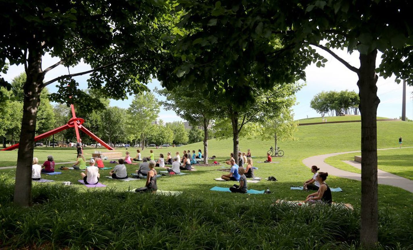 The Downtown Minneapolis Neighborhood Association has worked in conjunction with the Gold Medal Park Foundation in order to offer up free yoga classes for the growing population of Minneapolis. Here, participants in the yoga class begin their morning Saturday, June 17, 2017, in Gold Medal Park in Minneapolis, MN.