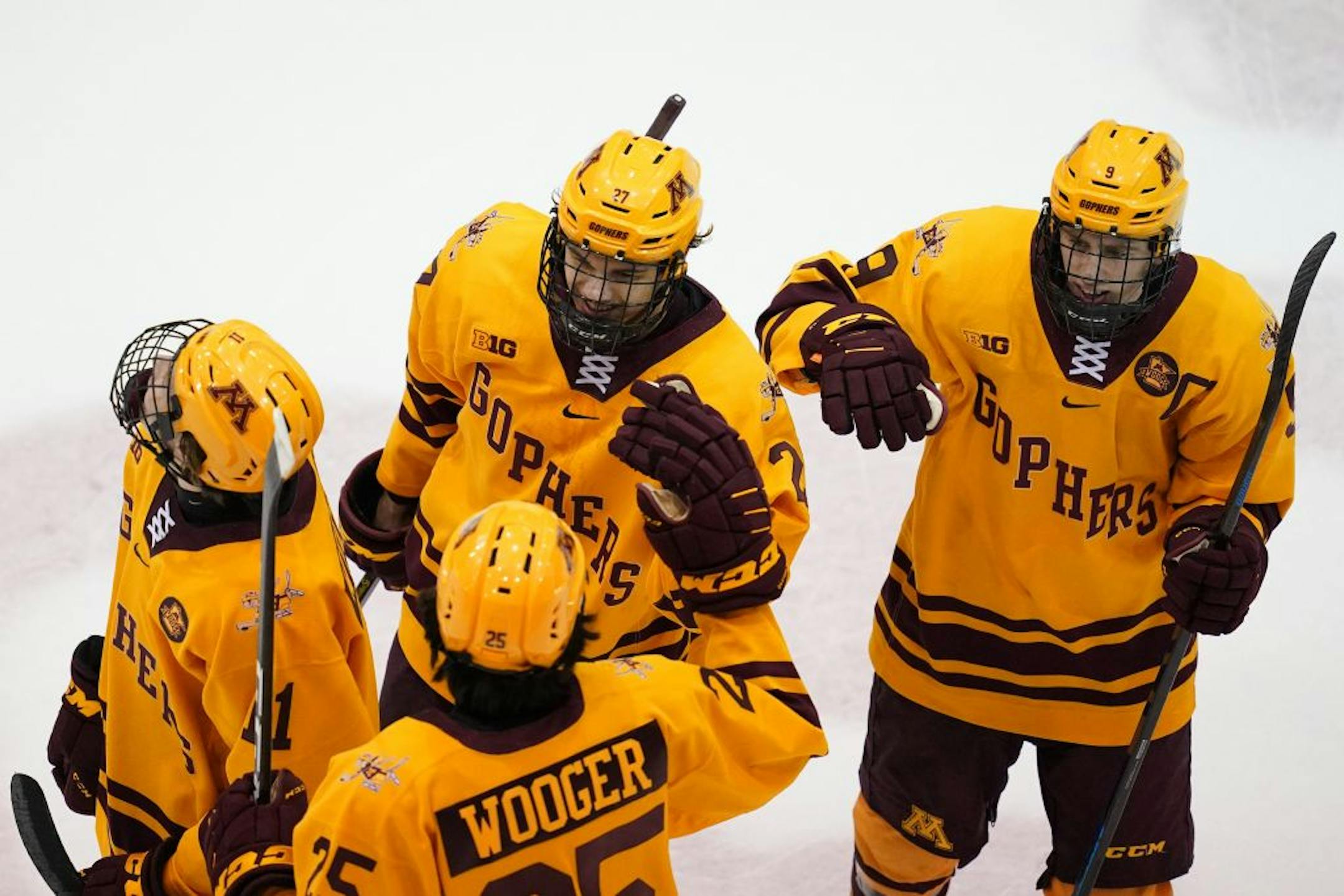 Gophers forward Blake McLaughlin (27) was congratulated by his teammates after he scored the game winning goal on an outside shot past Beavers goaltender Zach Driscoll (33) in the third period.