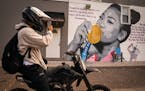 Tory Barber of St. Paul stopped to take a photo of a mural of Suni Lee on a building off Robert Street on the west side of St. Paul. ] LEILA NAVIDI �