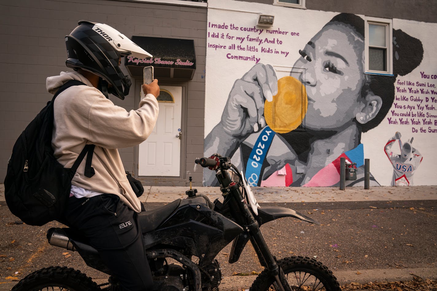 Tory Barber of St. Paul stopped to take a photo of a mural of Suni Lee on a building off Robert Street on the west side of St. Paul. ] LEILA NAVIDI • leila.navidi@startribune.com