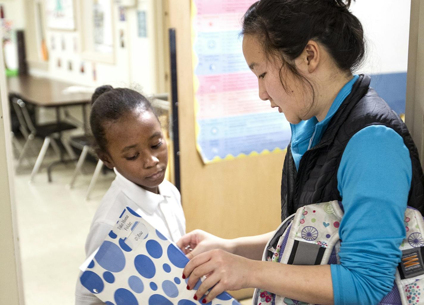 Elementary educator Jenny Neidich, right, checks to see if D&#xed;Asia Franklin, 7, has completed homework from school at the Banyan Community in Minneapolis. Banyan is building a $6 million center in the Phillips neighborhood.