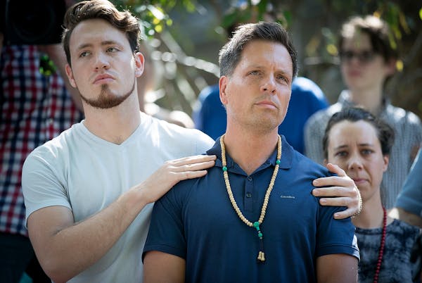 Don Damond, fiance of Justine Damond, is comforted by his son Zach Damond before he made a statement to the press near his home in Minneapolis.