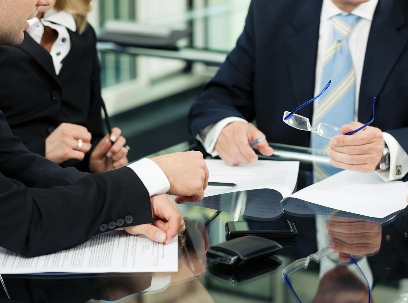 Business - meeting in an office; lawyers or attorneys discussing a document or contract agreement