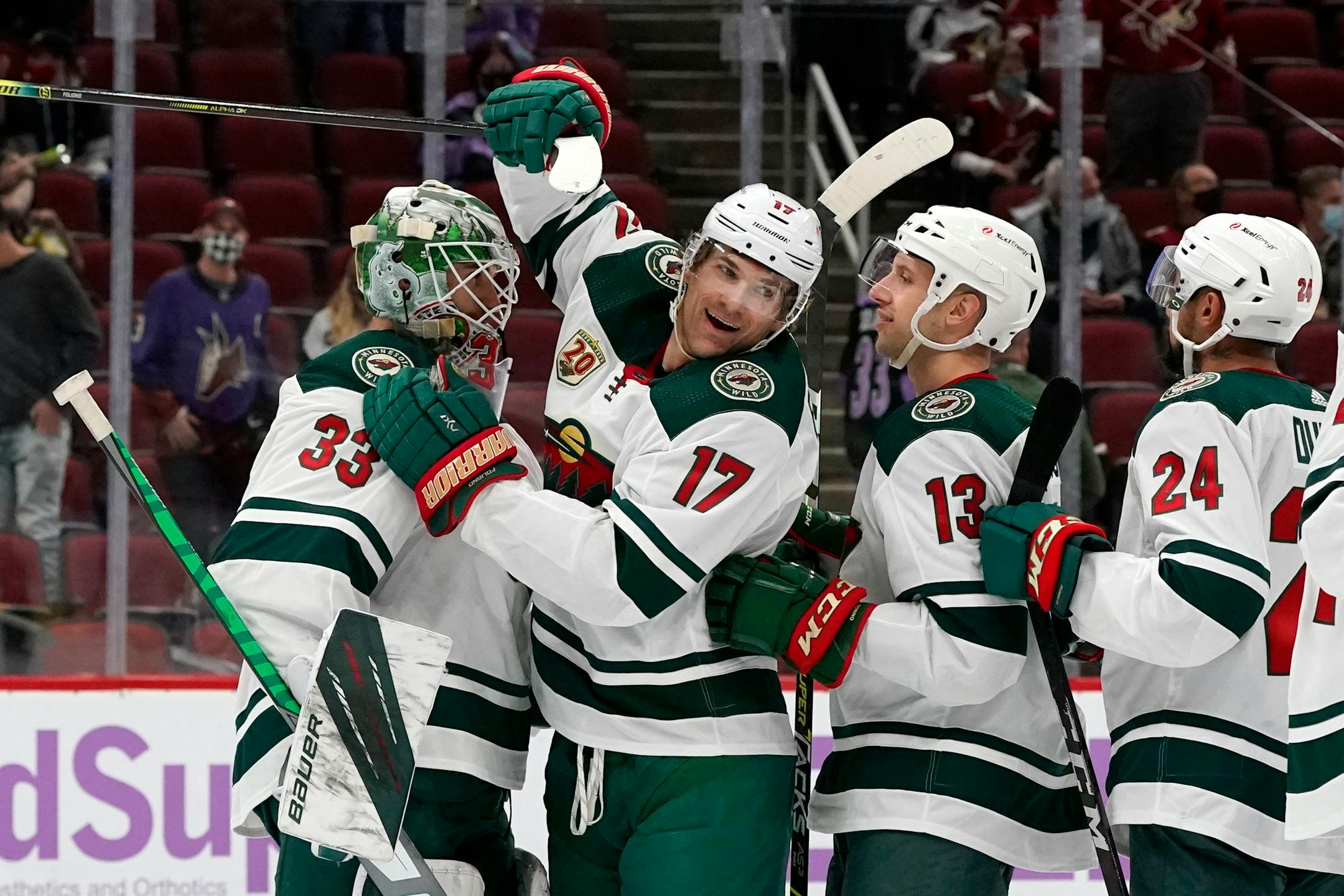 Minnesota Wild goaltender Cam Talbot (33) celebrates a win against the Arizona Coyotes with Wild's Marcus Foligno (17), Nick Bonino (13), and Matt Dumba (24) after an NHL hockey game Monday, April 19, 2021, in Glendale, Ariz. (AP Photo/Ross D. Franklin)