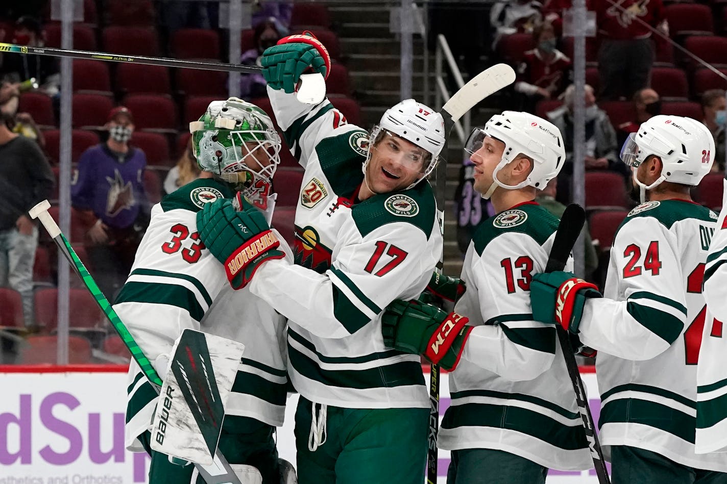 Minnesota Wild goaltender Cam Talbot (33) celebrates a win against the Arizona Coyotes with Wild's Marcus Foligno (17), Nick Bonino (13), and Matt Dumba (24) after an NHL hockey game Monday, April 19, 2021, in Glendale, Ariz. (AP Photo/Ross D. Franklin)