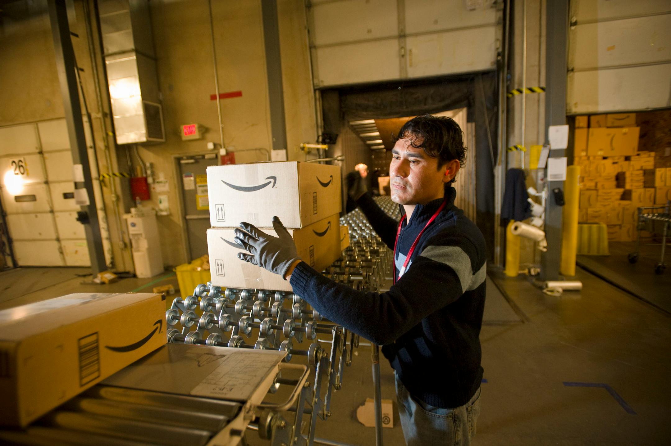 In this Dec. 1, 2008 file photo, an Amazon.com employee grabs boxes to be loaded onto a truck at the company's Fernley, Nev. warehouse. States are increasingly looking to collect taxes from online retail sales as a way to fill gaps in budgets, with New York going as far as to pass a bill that requires companies like Amazon.com Inc. to collect taxes on shipments to New York residents, even if the companies' operations are located elsewhere.