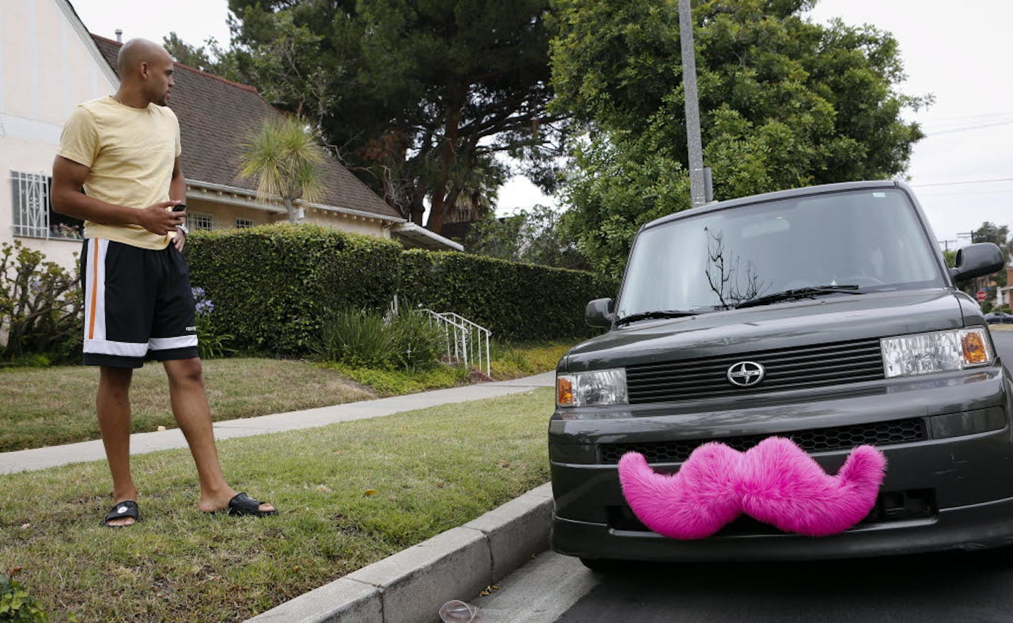 Justin Riley next to his car, which sports the signature pink mustache of Lyft, a smartphone app based ride-sharing service, in West Hollywood, June 25, 2013.