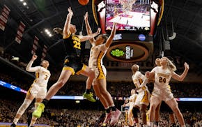 Caitlin Clark (22) of the Iowa Hawkeyes is defended by Ayianna Johnson (1) of the Minnesota Golden Gophers in the first half.