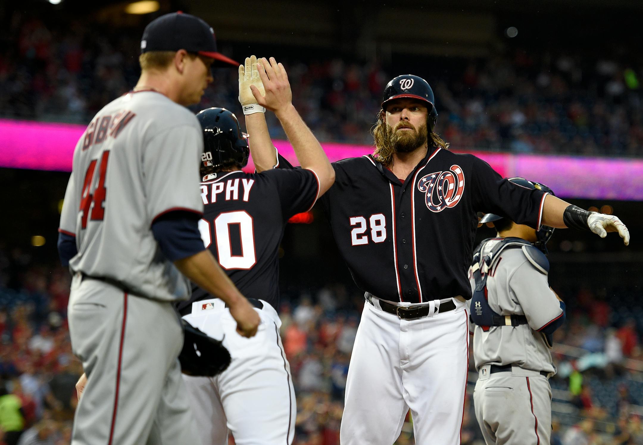 Washington Nationals' Jayson Werth (28) high-fives teammate Daniel Murphy (20) as they both scored on a single by Jose Lobaton during the first inning of an interleague baseball game against the Minnesota Twins, Friday, April 22, 2016, in Washington. Twins starting pitcher Kyle Gibson (44) looks on. (AP Photo/Nick Wass)