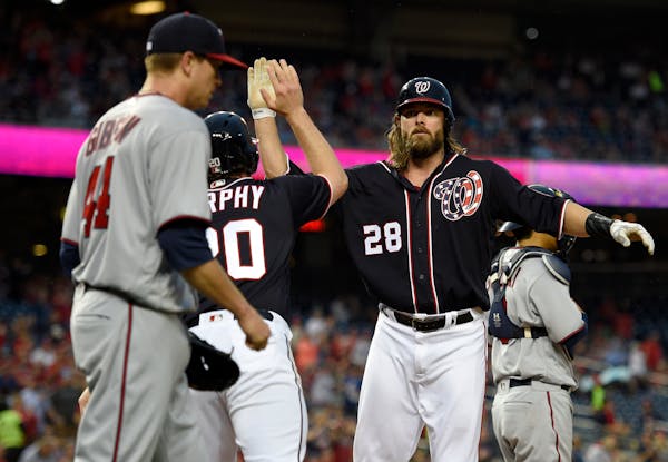 Washington Nationals' Jayson Werth (28) high-fives teammate Daniel Murphy (20) as they both scored on a single by Jose Lobaton during the first inning