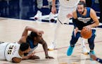 Minnesota Timberwolves guard Ricky Rubio, right, picks up a loose ball after Denver Nuggets guard PJ Dozier, left front, lost control while tangling w