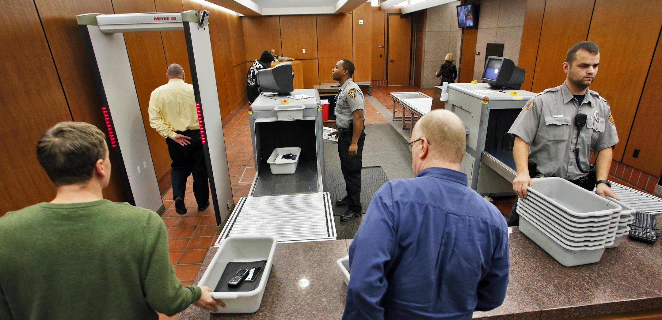 Courthouse screening is expanding in the metro area. A visual look at the screening area of the Hennepin County Government Center in Minneapolis. Viking Security agents Carlo Griggs, left, and Jon Kline checked people as they proceeded through the security machines. (MARLIN LEVISON/STARTRIBUNE(mlevison@startribune.com) ORG XMIT: MIN1312061527221829