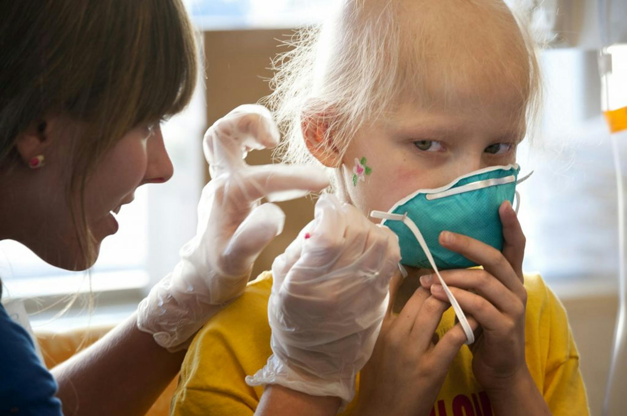 Jessie Masterman painted a flower on the cheek of Lauren Larson, a patient at Children's Hospital in Minneapolis, as part of Give to the Max Day on Thursday.