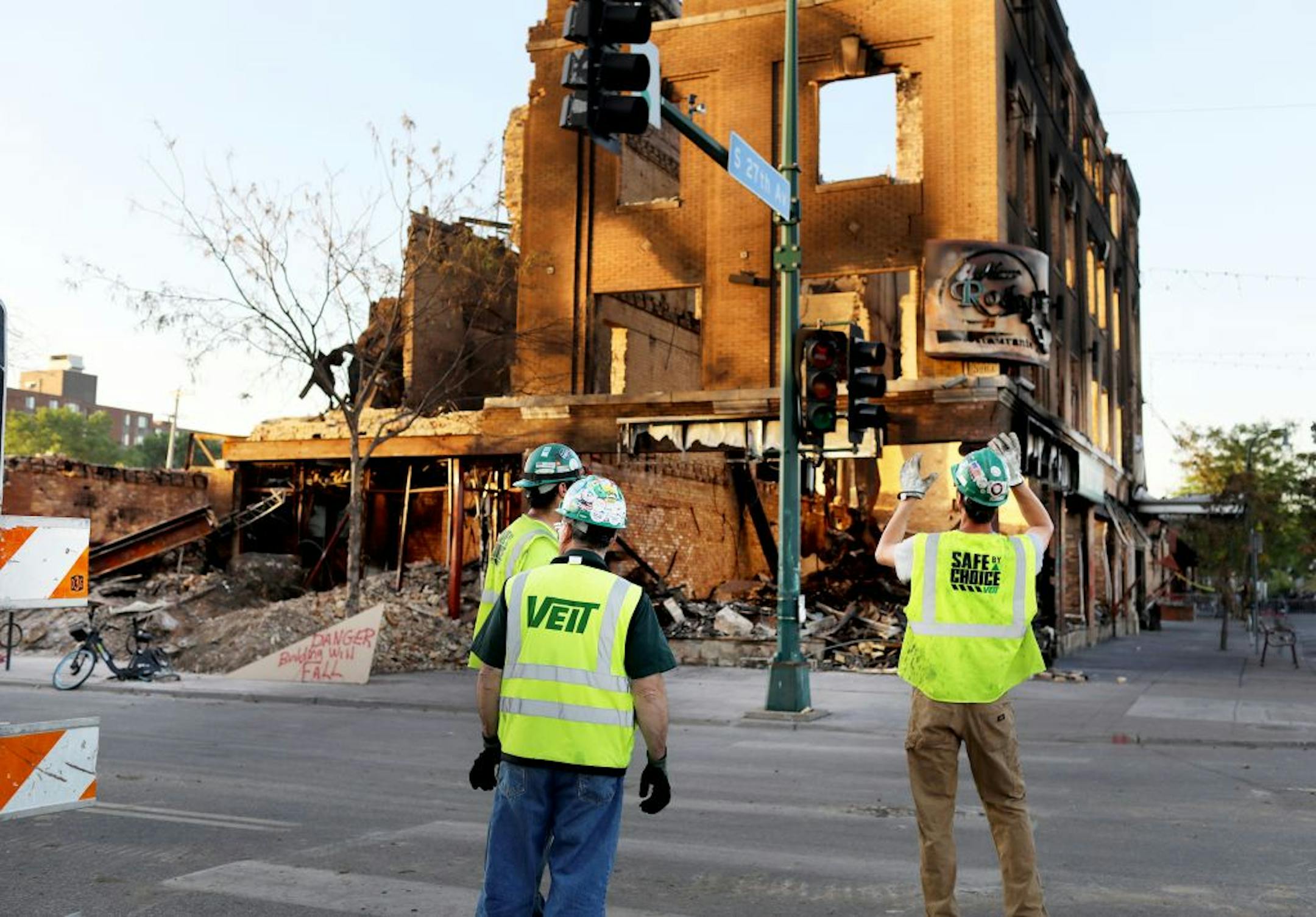 Workers looked at the burned-out shell of the building that housed El Nuevo Rodeo near Lake St. and S. 27th Avenue.