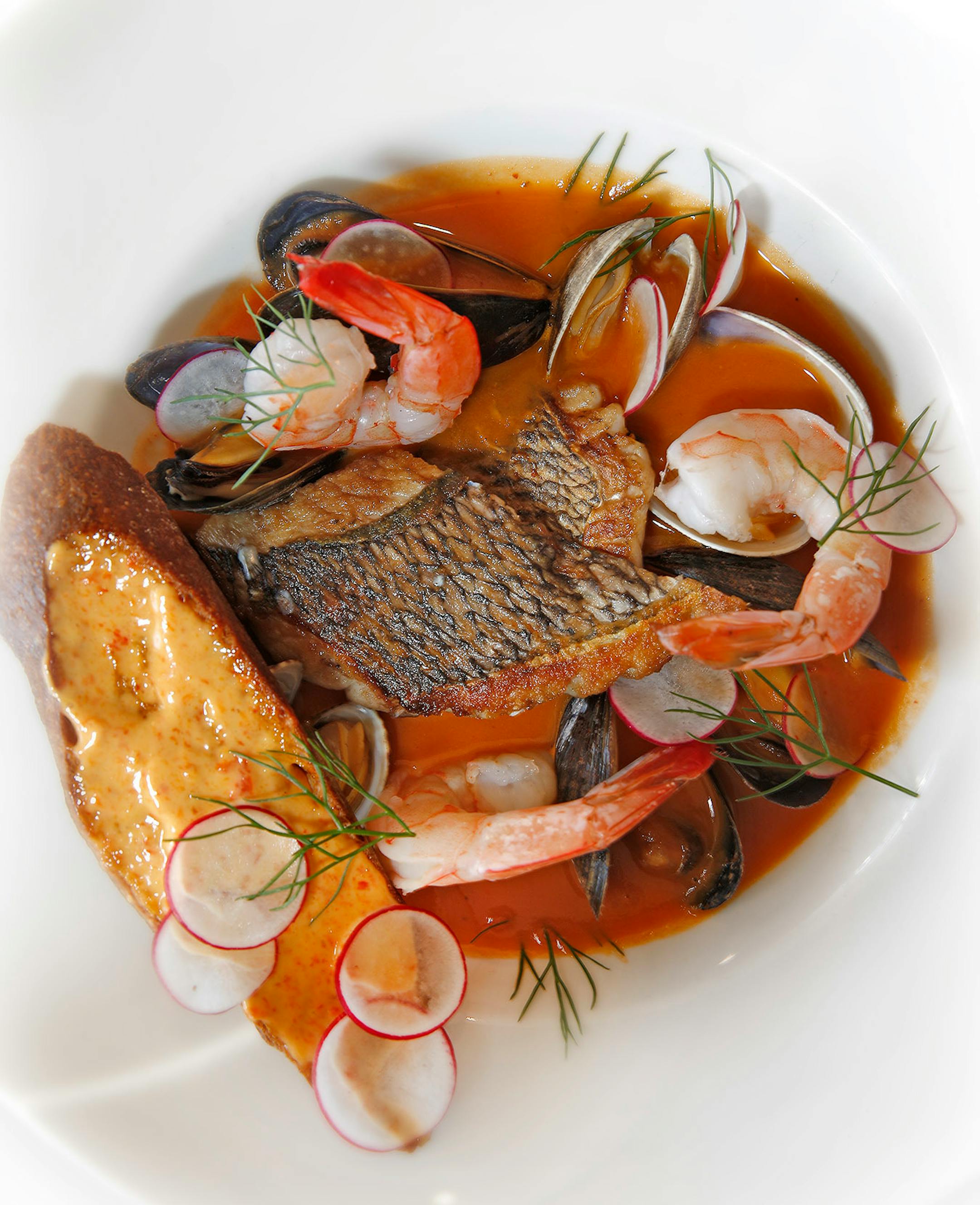 Bouillabaise, dish of Bellecour sea bass, shrimp, clams, baguette, rouille.