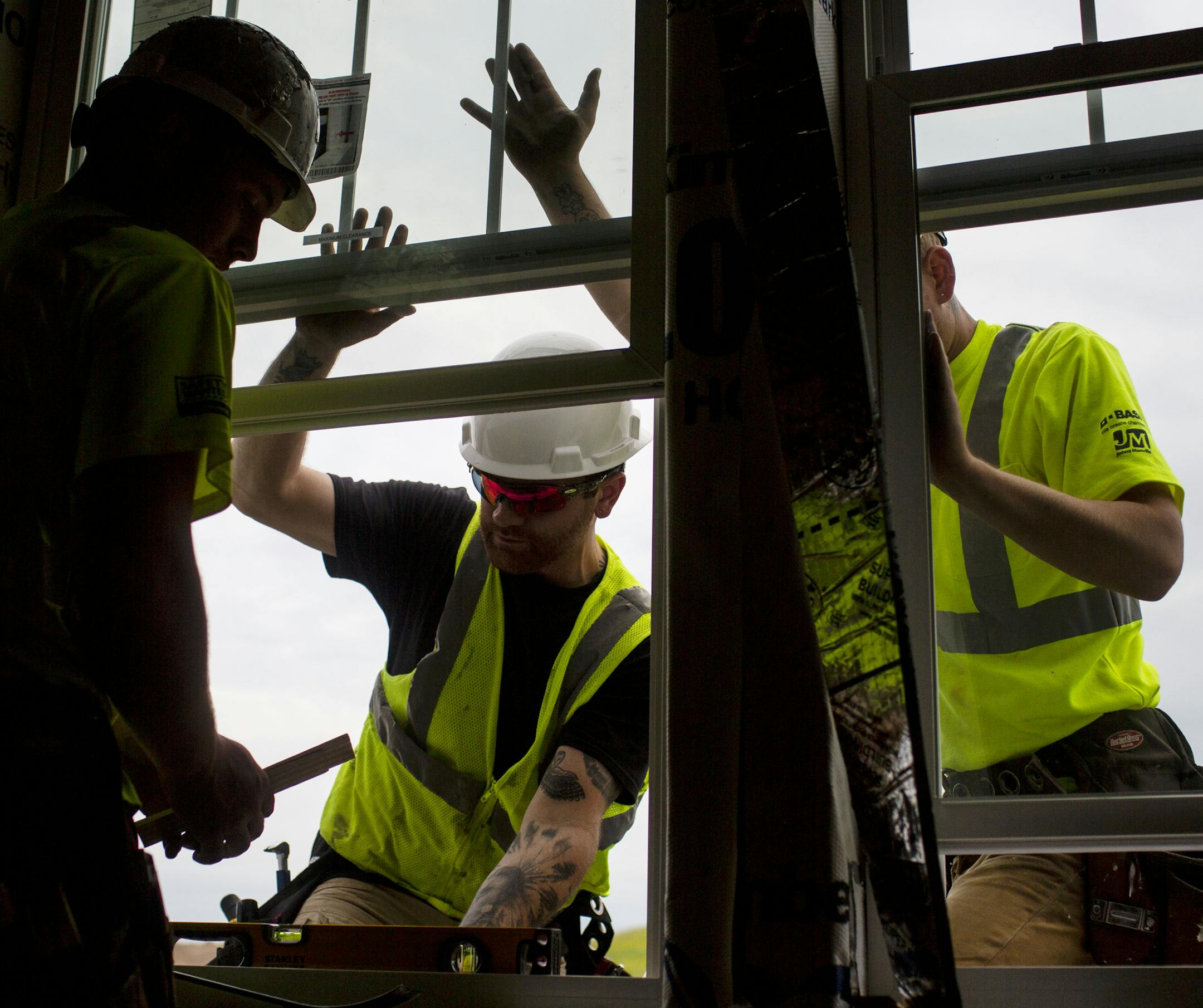 Gabe Totzke (left) and Donald Hetrick install a second-floor window. ] NICOLE NERI • nicole.neri@startribune.com BACKGROUND INFORMATION: Construction crews work on building homes in the Donegal neighborhood Thursday, June 27, 2019.