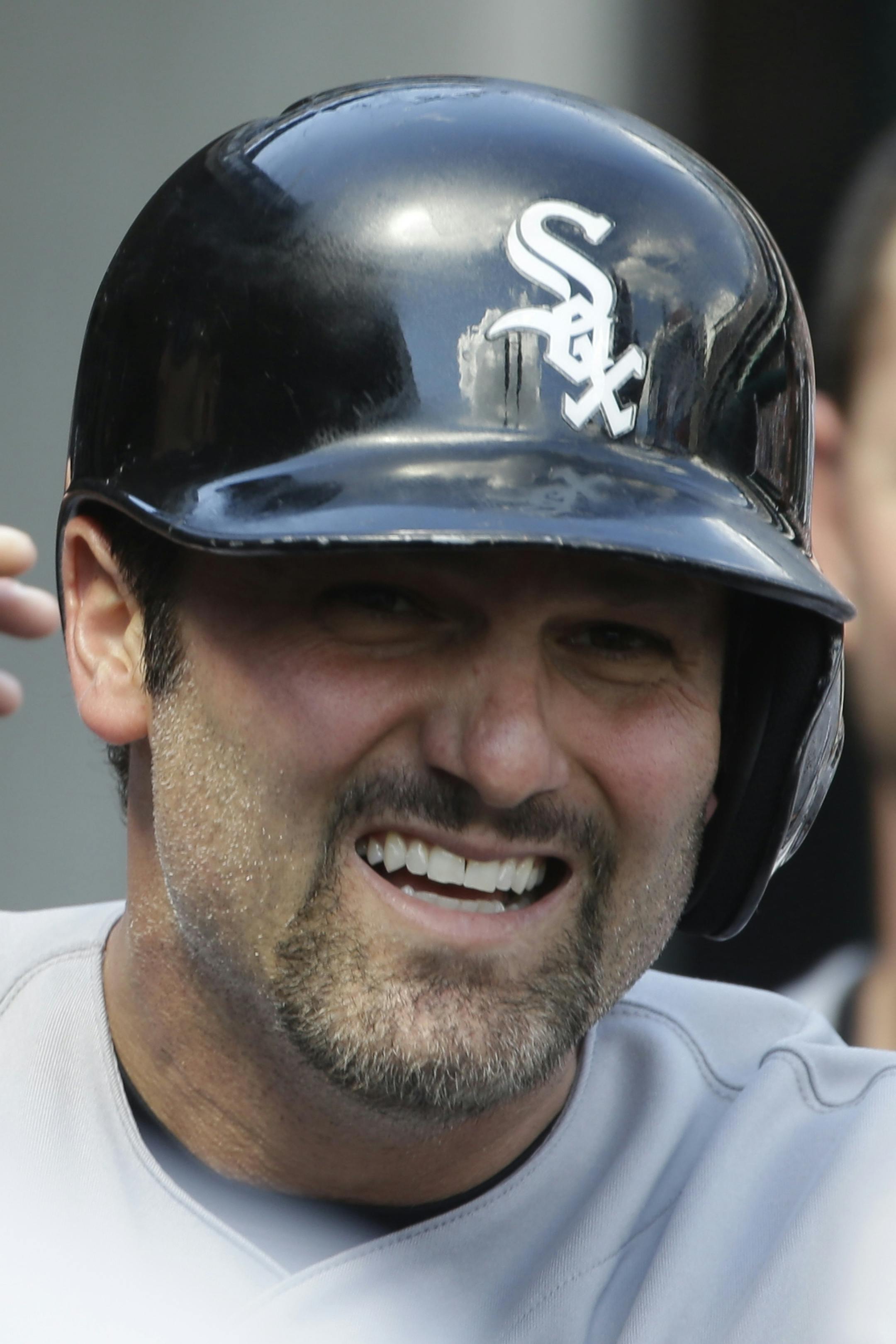 Chicago White Sox's Paul Konerko is congratulated in the dugout after hitting a solo home run during the ninth inning of a baseball game against the Detroit Tigers in Detroit, Sunday, Aug. 4, 2013. (AP Photo/Carlos Osorio) ORG XMIT: MIN2013081620592058