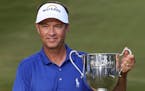 Davis Love III poses with the trophy after winning the Wyndham Championship golf tournament at Sedgefield Country Club in Greensboro, N.C., Sunday, Au