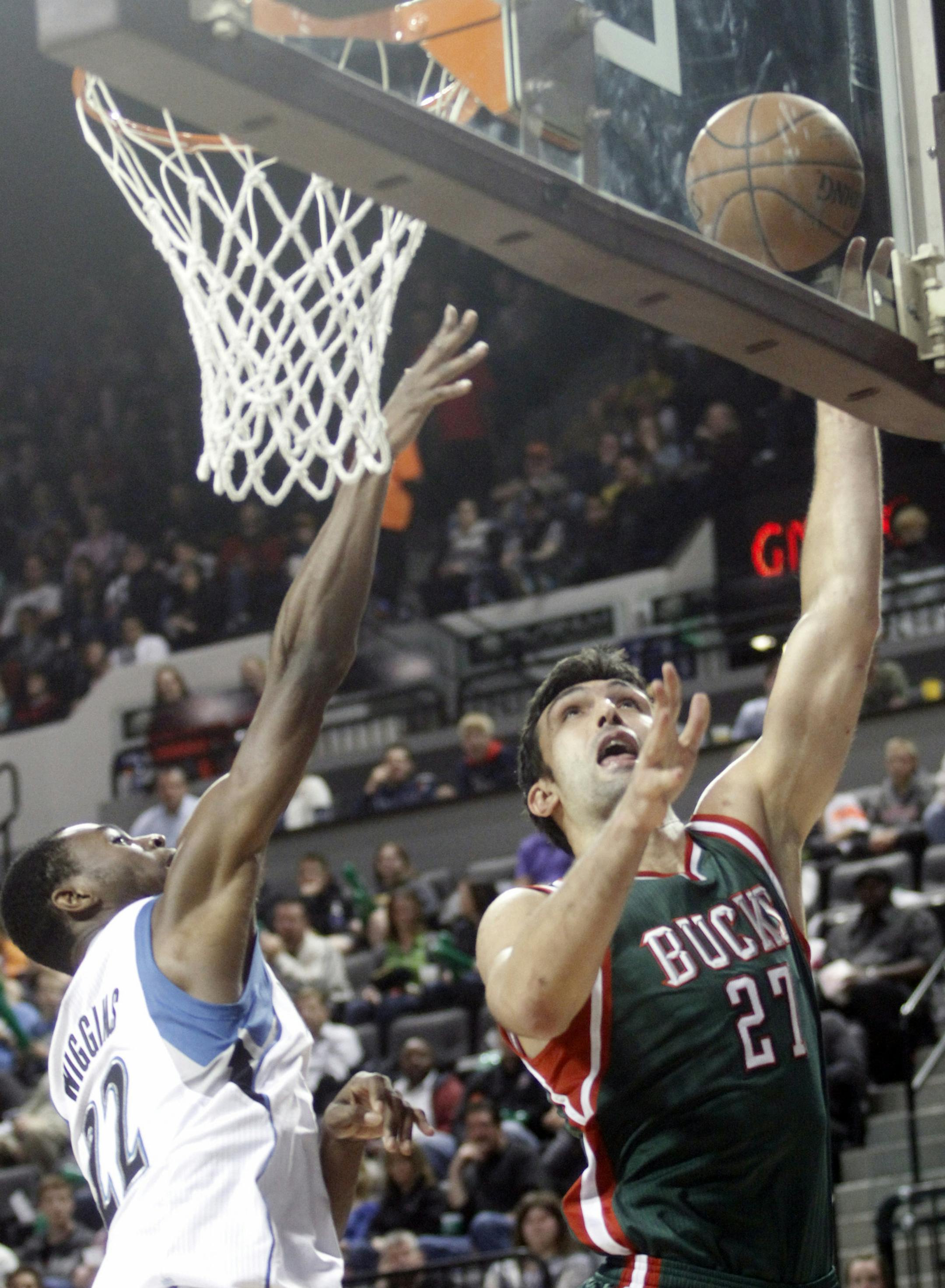 Milwaukee Bucks center Zaza Pachulia, right, drives to the basket past Minnesota Timberwolves forward Andrew Wiggins during the first half of a preseason NBA basketball game, Friday, Oct. 17, 2014, in Cedar Rapids, Iowa. (AP Photo/Matthew Holst)