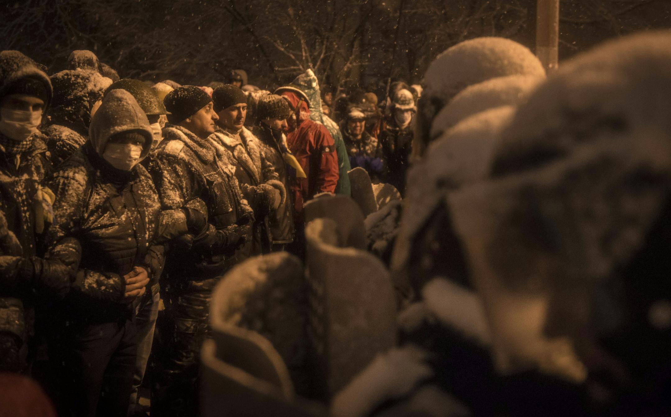 Protesters stand arm-in-arm in front of a police line in Kiev, Dec. 9, 2013. After largely waving off a national uproar for two weeks, President Viktor F. Yanukovych said Monday he would accept a proposal by three predecessors to hold round-table talks with opposition leaders. (Sergey Ponomarev/The New York Times)