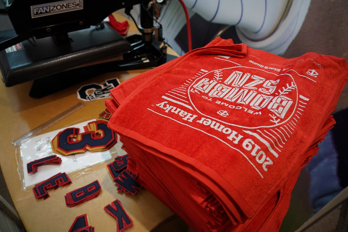 The Minnesota Twins unveiled the 2019 version of the Homer Hanky as the team returns to Major League Baseball postseason play for the first time in nine years. Season ticket holders were invited into Bat & Barrel for a special unveiling event while people waited in line for the store to sell the red towels (limit 10 per customer) for three dollars each. The Homer Hankies will be on sale in various locations until they sell out. In this photo, a stack of Homer Hankies sat on a table with letters