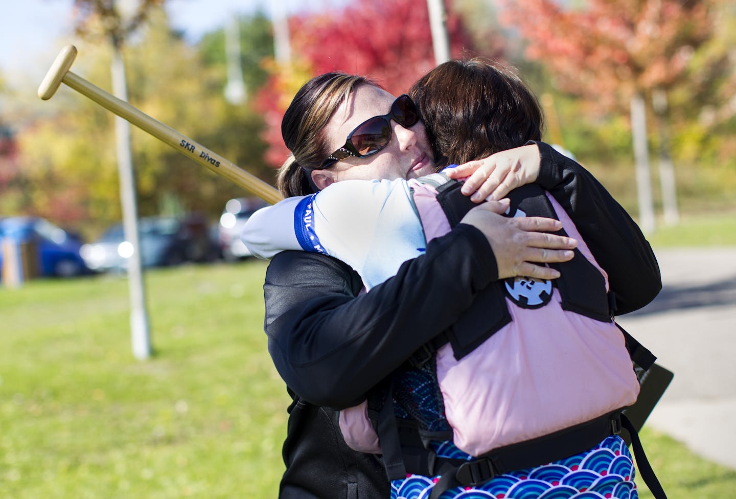 Kim Schminkey, left, and Dr. Sandra Rosenberg share a tender moment as the Dragon Divas meet to train on Lake Gervais in Little Canada October 11, 2014. The women gather for vigorous exercise but also function as a support group. (Courtney Perry/Special to the Star Tribune)