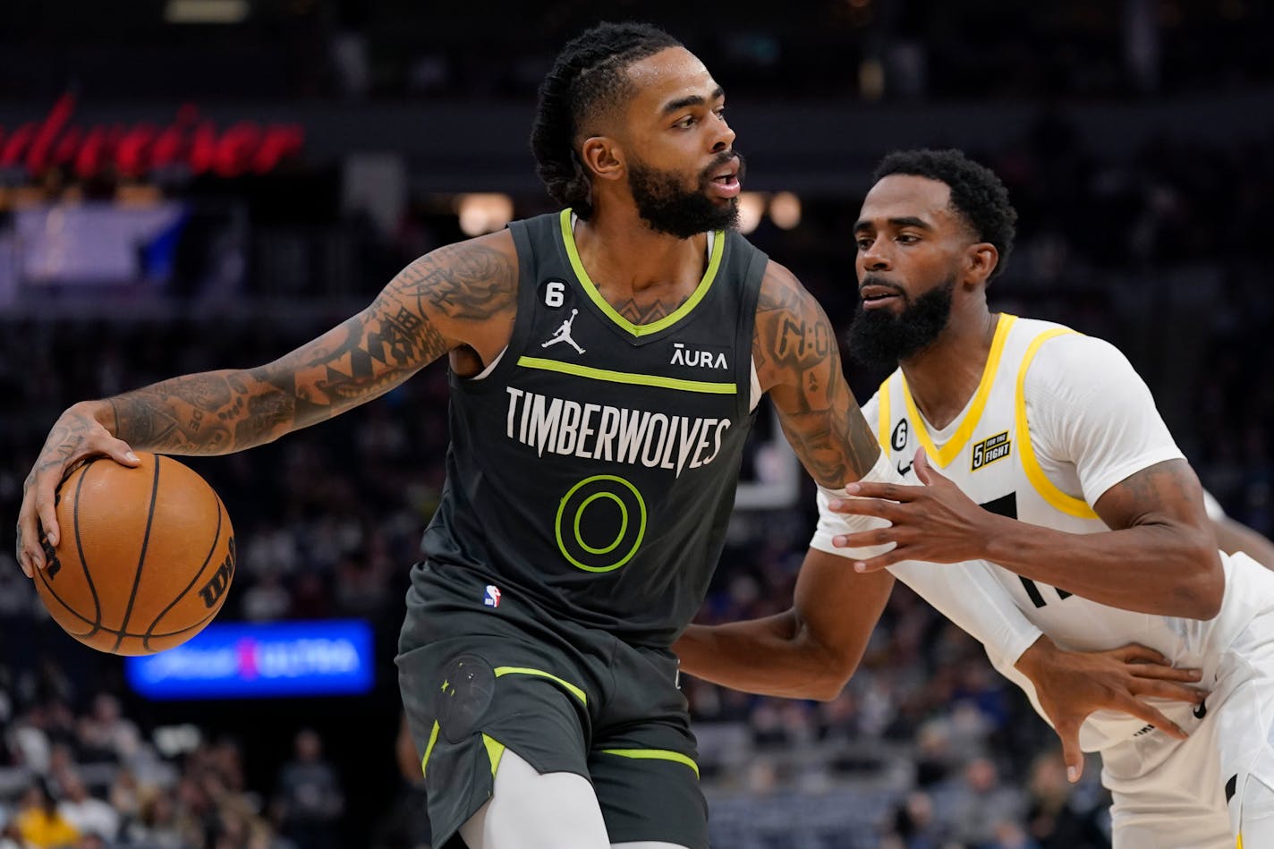 Minnesota Timberwolves guard D'Angelo Russell (0) works toward the basket while defended by Utah Jazz guard Mike Conley (11) during the second half of an NBA basketball game Friday, Oct. 21, 2022, in Minneapolis. (AP Photo/Abbie Parr)