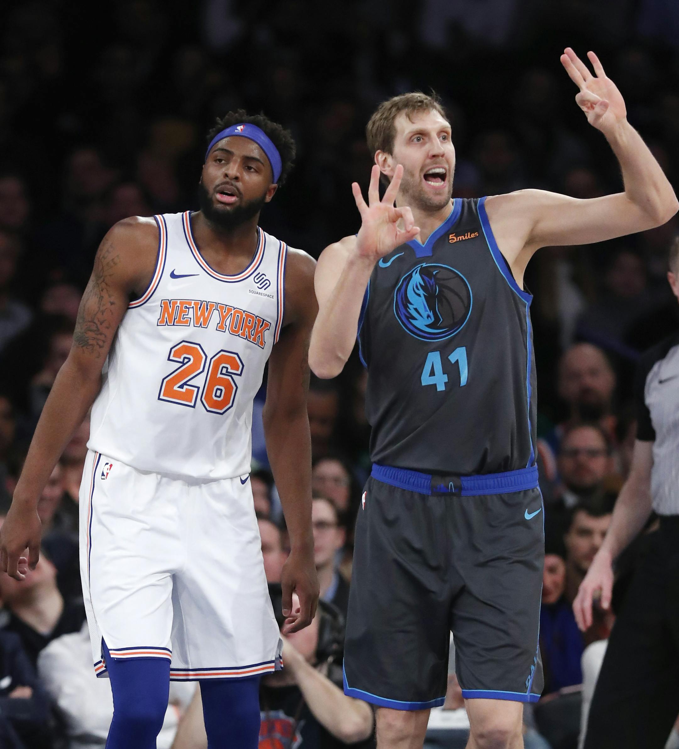 Dallas Mavericks forward Dirk Nowitzki (41) signals to his bench with New York Knicks center Mitchell Robinson (26) awaiting the an official's call during the first half of an NBA basketball game, Wednesday, Jan. 30, 2019, in New York. (AP Photo/Kathy Willens)